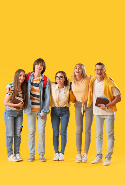 Group of teenage students on yellow background - 写真・画像