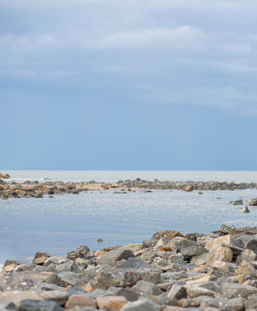 Lots of rocks by the sea, clear sky sea background. - Zdjęcie, obraz