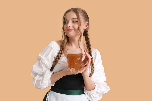 Mooie oktober serveerster met bier op beige achtergrond - Foto, afbeelding