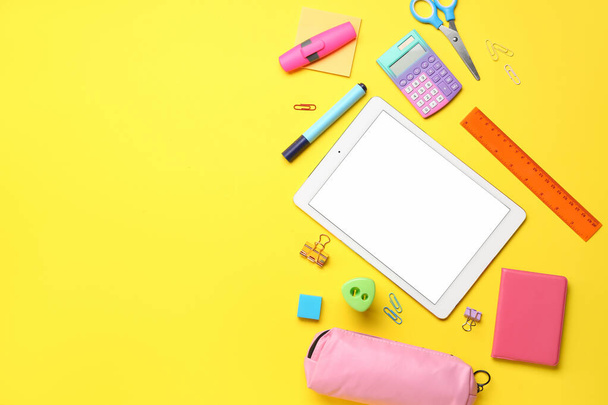 Different stationery with tablet and calculator on yellow background - Photo, Image