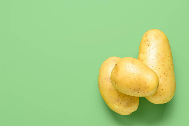 Raw potatoes on green background - Photo, image