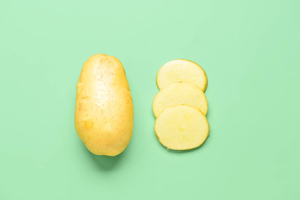 Whole and cut potatoes on green background - Fotoğraf, Görsel