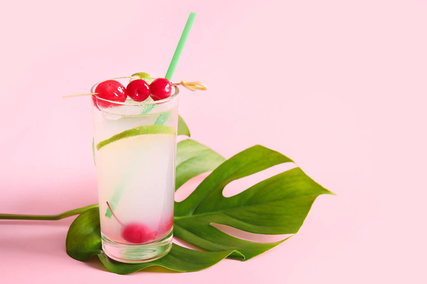 Glass of tasty cocktail with maraschino cherries on pink background - Photo, Image