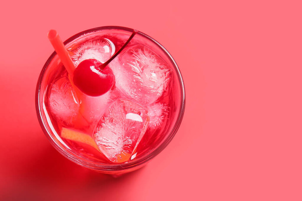 Glass of tasty cocktail with maraschino cherry on red background - Photo, Image