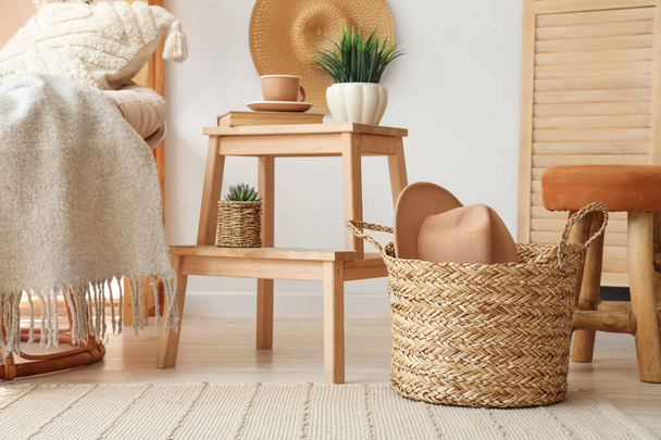 Wicker basket with hat in living room interior - Foto, imagen