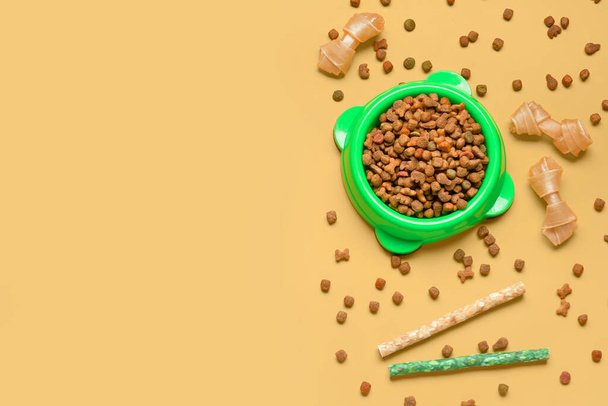 Composition avec nourriture sèche pour chien et friandises sur fond de couleur - Photo, image