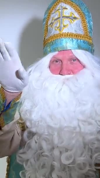 De Kerstman kijkt naar de camera, toont zijn hart en geeft hart, geïsoleerd in witte achtergrond. Hoge kwaliteit 4k beeldmateriaal - Video