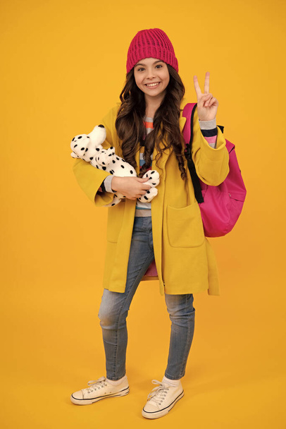 Autumn school. Funny school girl with toy isolated on yellow background. Happy childhood and kids education. Happy teenager, positive and smiling emotions of teen girl - Фото, зображення