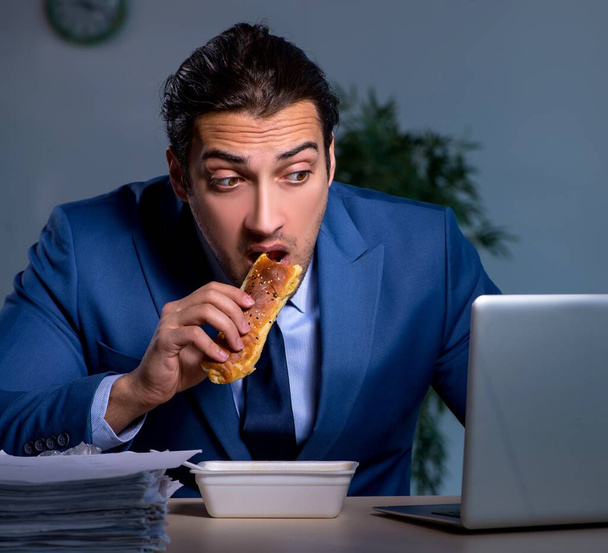 Hungry employee working late in office - Фото, зображення