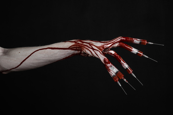 Bloody hand with syringe on the fingers, toes syringes, hand syringes, horrible bloody hand, halloween theme, zombie doctor, black background, isolated - Фото, зображення