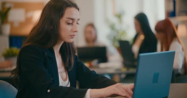 Slow motion van jonge zakenvrouw met behulp van laptop aan het bureau in kantoor. - Video