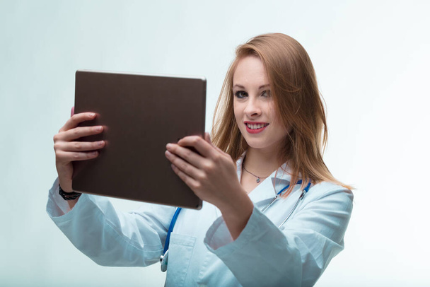 Młody lekarz korzystający z tabletu cyfrowego, zanurzający Cię w niezwykłym świecie digitalizacji opieki zdrowotnej i internetu - Zdjęcie, obraz