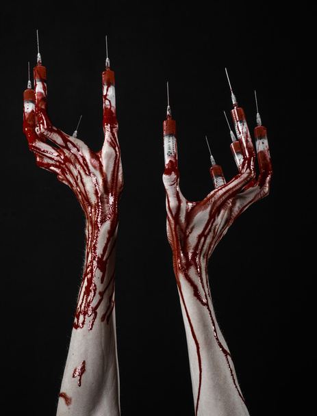Véres kéz, az ujjak, lábujjak fecskendők, kézi fecskendő, borzalmas és véres kéz, halloween témát, zombi orvos, fekete háttér, elszigetelt fecskendővel - Fotó, kép
