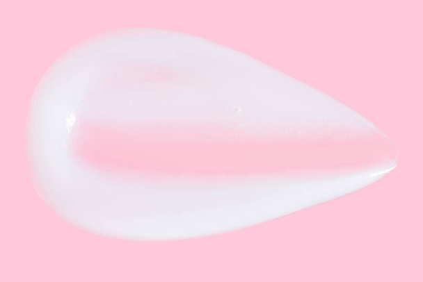 Una mancha de grasa. crema sobre un fondo rosa.  - Foto, Imagen