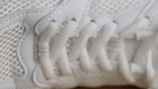 Close-up, Perforated White Leather Sneaker Surface Texture. Laces, mesh, holes, fabric structure. Side view. Blurred slow camera movement from toe to heel. Inside. Female shoe. Fitness. Sports. - Footage, Video