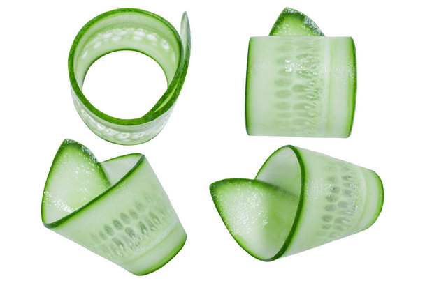 A set of thinly sliced twisted slices of fresh green cucumber on a white background. - Photo, Image
