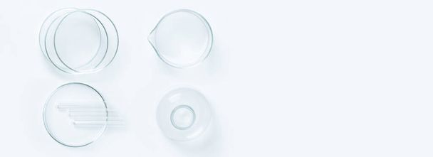 una serie di oggetti di vetro da laboratorio su sfondo chiaro. Piatti, fiaschette, tazze di Petri. - Foto, immagini