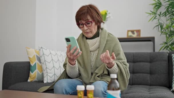 Ώριμη ισπανόφωνη γυναίκα που είναι άρρωστη σε online ραντεβού με το γιατρό στο σπίτι - Πλάνα, βίντεο