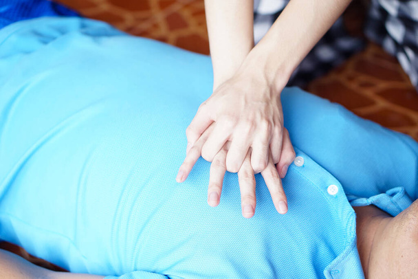 Close up hands  pump on chest for first aid emergency CPR of unconscious man. Concept, Heath care, life rescuse. CPR Cardiopulmonary Resuscitation. Heart pumping for unconscious person.          - Zdjęcie, obraz