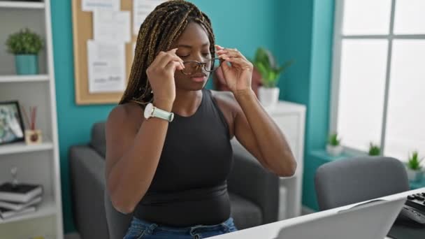 Afroamerykanka kobieta biznes pracownik noszenie okularów za pomocą laptopa w biurze - Materiał filmowy, wideo