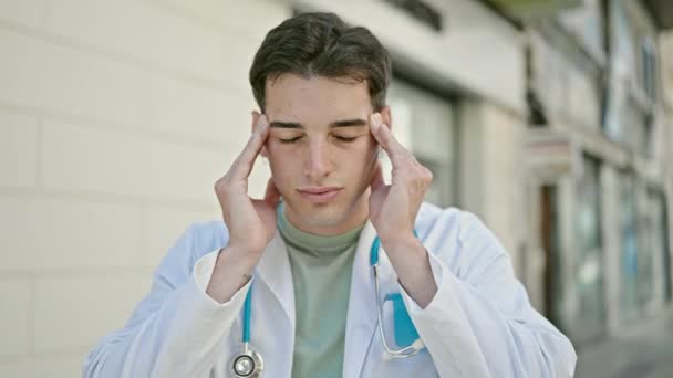 Joven médico hispano estresado sufriendo dolor de cabeza en el hospital - Metraje, vídeo