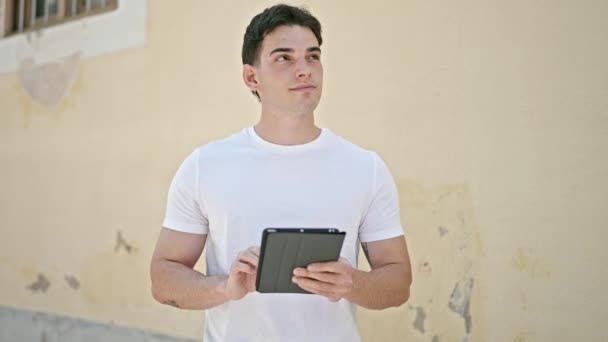 Fiatal spanyol férfi használja touchpad az utcán - Felvétel, videó