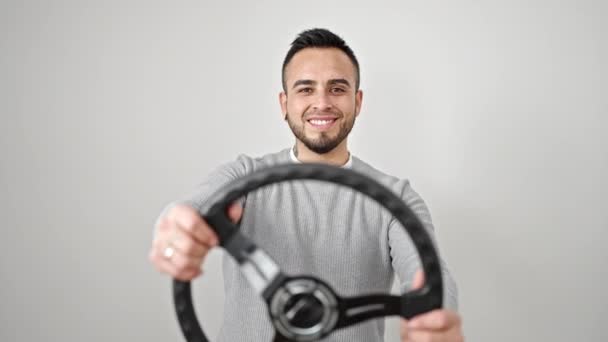 Latinomies hymyilee luottavainen käyttäen ohjauspyörän kuljettaja yli eristetty valkoinen tausta - Materiaali, video