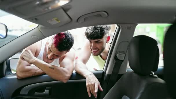 Δύο άνδρες ζευγάρι κοιτάζοντας μέσα από το νέο αυτοκίνητο στο δρόμο - Πλάνα, βίντεο