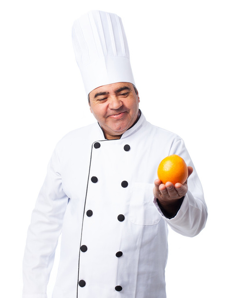 Cook man holding orange - Foto, imagen