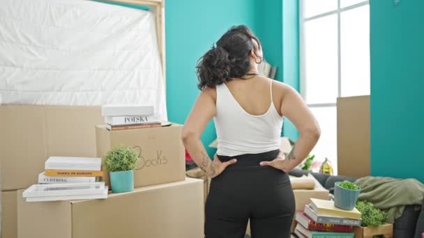 Mujer hispana hermosa joven mirando alrededor de pie hacia atrás en el nuevo hogar - Imágenes, Vídeo