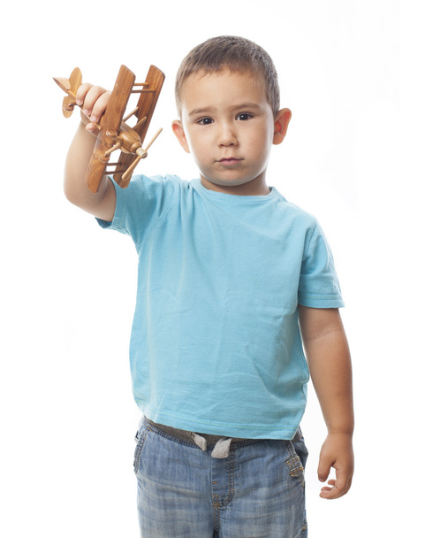 Boy playing with a wooden biplane - Фото, изображение