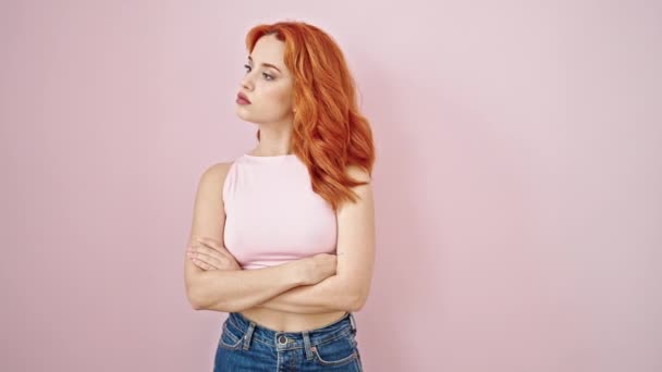 Young redhead woman smiling confident standing over isolated pink background - Footage, Video