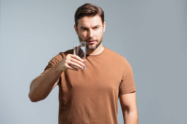 Drinking water. Hispanic man enjoy pure fresh mineral water. Thirsty man hold glass aqua water. Healthy waters to refreshment. Millennial 40s man drinking water isolated on studio background - Foto, afbeelding
