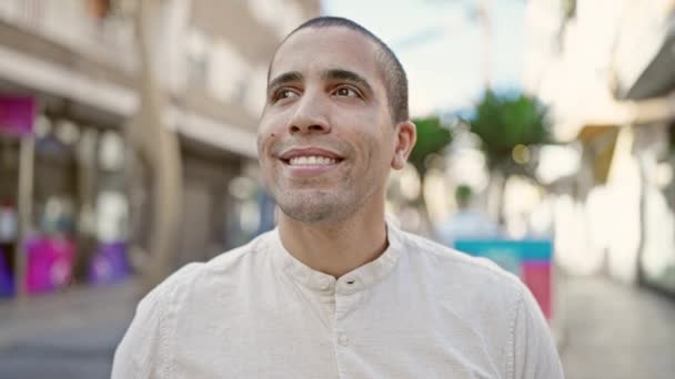 Молодий іспаномовний чоловік посміхається впевнено стоїть на вулиці
 - Кадри, відео