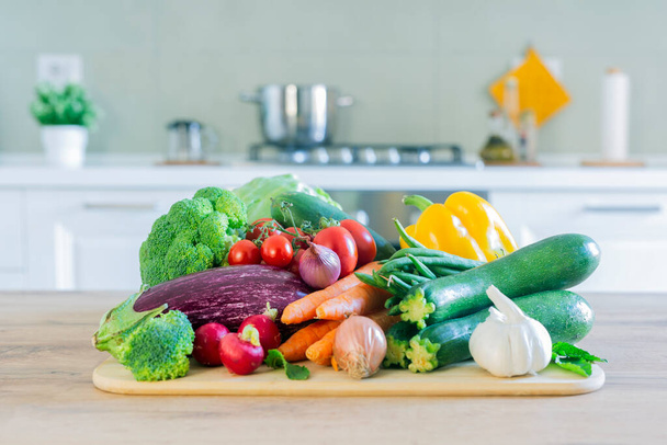 テーブルの上に野菜とスタイリッシュなモダンなキッチン。家庭用品と明るい白いキッチン。健康的なライフスタイルの概念. - 写真・画像