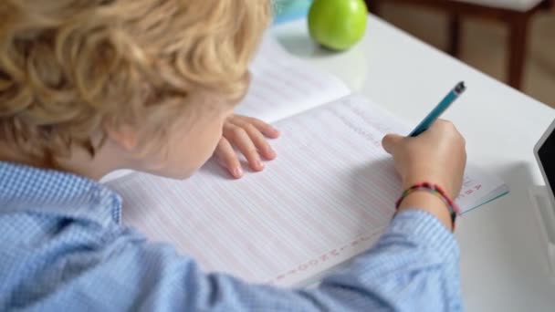 Elementary school student boy or girl writing letters, studying at desk. Back to school over white background. First lesson, alphabet, pupil knowledge. Copy space for advertisement. - Footage, Video