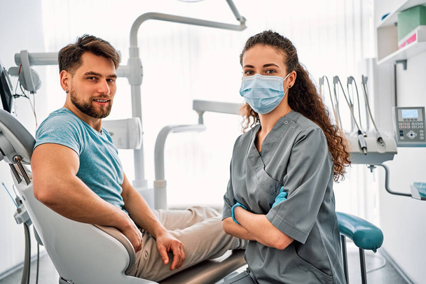 Dentistry, medicine. Dentistry, medicine. Doctor and patient in dental office looking at camera and smiling. - Фото, изображение
