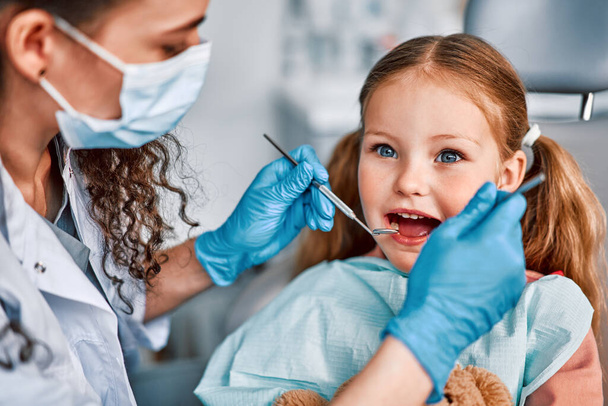 At the doctor's appointment. Portrait of a child being examined by a dentist. - Photo, image