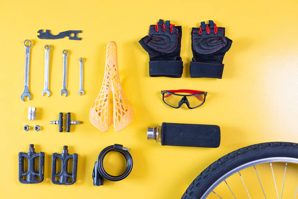 Set of different bicycle tools and parts on yellow background, flat lay. Space for text. - Photo, Image