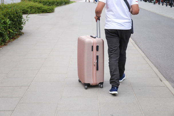 スーツケースを持った男がどこかに行く。休暇、旅行 - 写真・画像