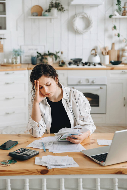 Stressed caucasian woman trying to deal with financial documents, having problem to find money to pay utility bills or loans. The concept of debt, bankrupt. Accounting companies advertisement mockup. - 写真・画像