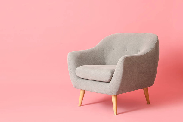 Grey armchair on pink background - Fotoğraf, Görsel