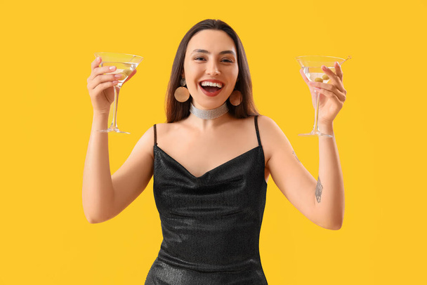 Belle femme avec martini sur fond jaune - Photo, image
