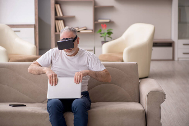 Uomo anziano godendo occhiali virtuali a casa - Foto, immagini