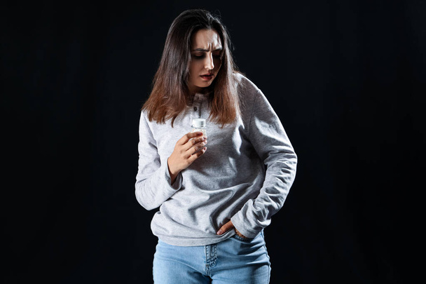 Drogenabhängige Frau mit Pillen auf schwarzem Hintergrund - Foto, Bild