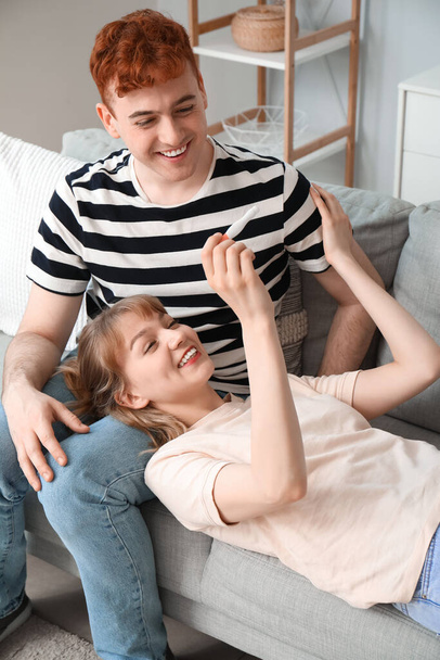Šťastný mladý pár s těhotenským testem doma - Fotografie, Obrázek