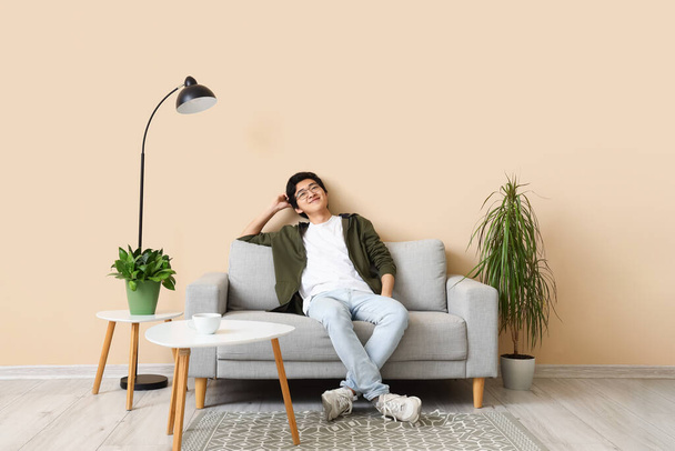 Giovane asiatico uomo riposo su suo giorno spento a casa - Foto, immagini