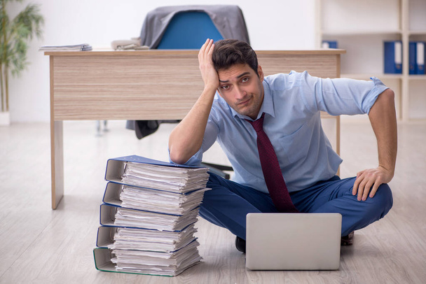 Young employee unhappy with excessive work at workplace - Foto, Imagen