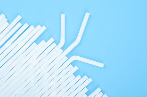 Group of plastic white drinking straw on blue background - Foto, Imagen