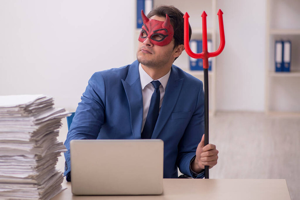 Homme d'affaires diabolique mécontent du travail excessif sur le lieu de travail - Photo, image